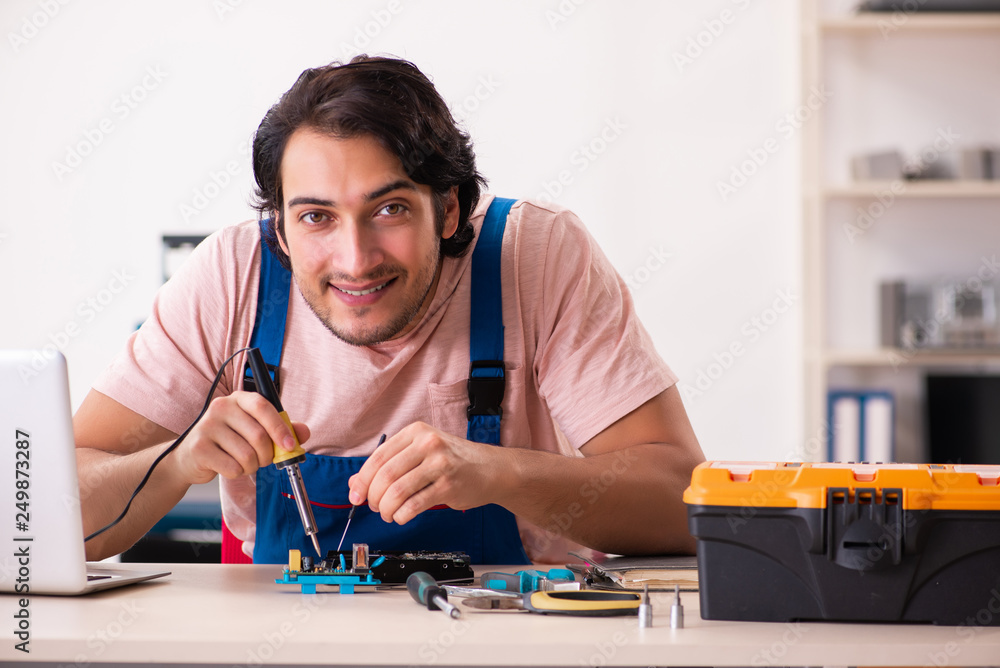 Young male contractor repairing computer Young male contractor repairing computer