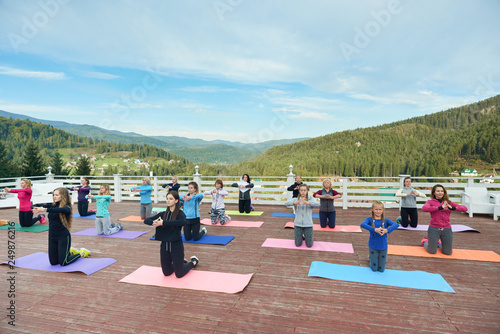 Women standing on knees on yoga mats, practicing.