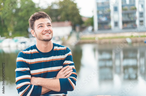 Smile beautiful cheerful man in front of river thinking positiv