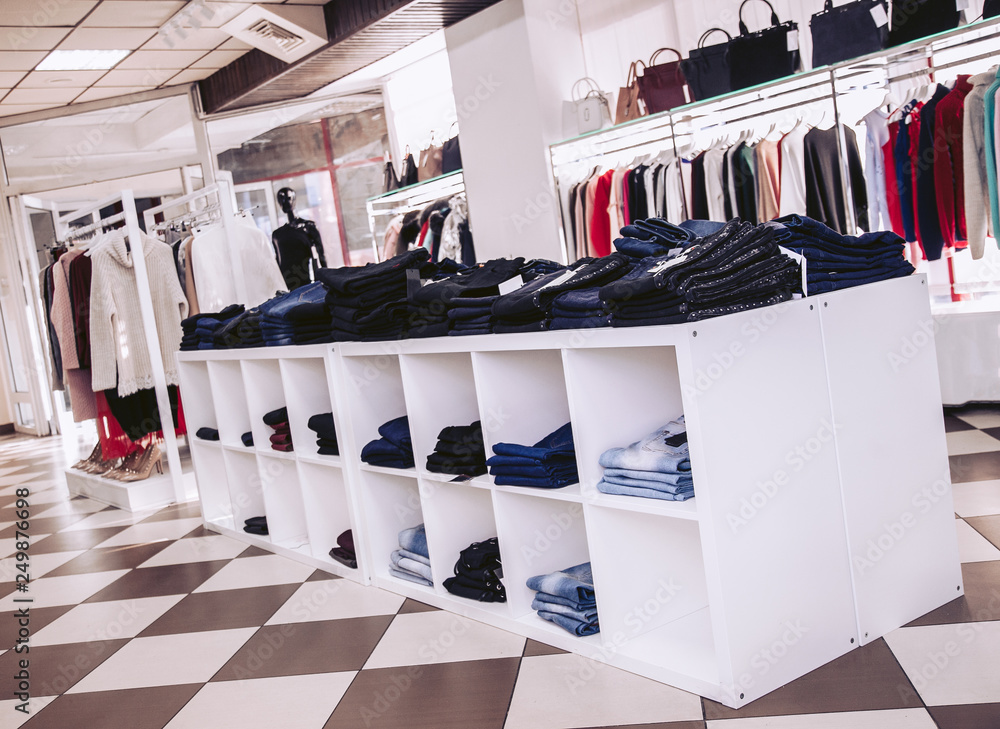 Interior of a clothing store in a shopping center. Shelves with jeans and  showcases with women's clothing. Stock Photo | Adobe Stock