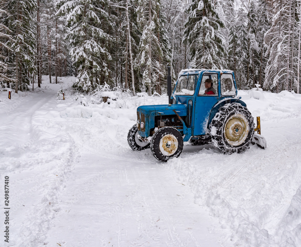 old blue fordson dexta tractor plowing snow