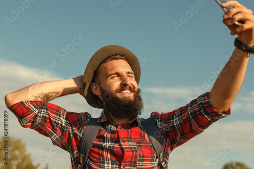 Cheerful traveler posing for selfie in countryside