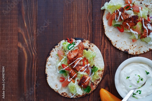 Homemade Chicken Tikka soft  Tacos drizzled with sour cream, overhead view