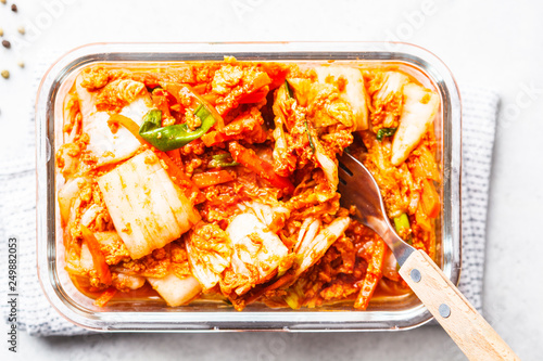 Kimchi cabbage in glass container, white background. Korean food, probiotics food.