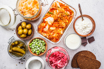 Probiotics food concept. Kimchi, beet sauerkraut, sauerkraut, cottage cheese, peas, olives, bread, chocolate, kefir and pickled cucumbers.
