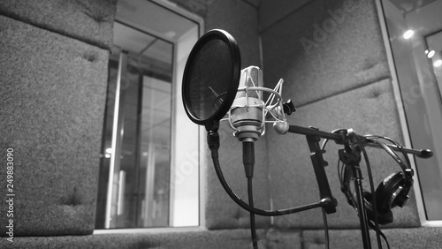 Studio microphone or mic for recording for vocal singer or commercial announcer with shock mount and pop filter on professional tripod in acoustic foam room for best sound and mix process photo