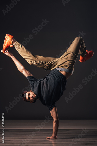 A man hip hop dancer or bboy freezes in one pose on the hand
