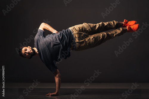 Tablou pe pânză A man hip hop dancer or bboy freezes in one pose on the hand