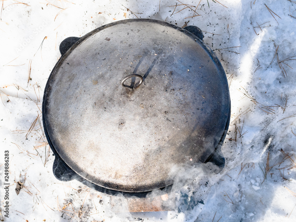 cauldron on open fire at snowy meadow cauldron on open fire at snowy meadow