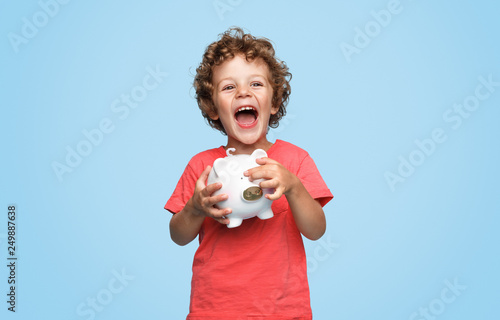 Excited boy with piggy bank