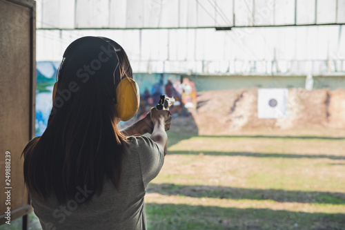 Fotografía Young woman practice gun shoot on target