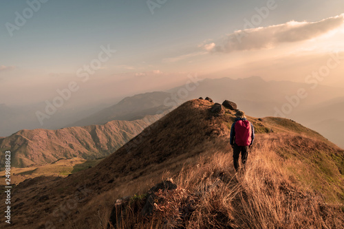 Young man traveler with backpack trekking on mountain, Adventure travel lifestyle concept