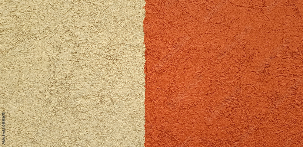 Two-colour concrete wall with rough texture - brown and orange color with swirly plaster patterns Two-colour concrete wall with rough texture - brown and orange color with swirly plaster patterns