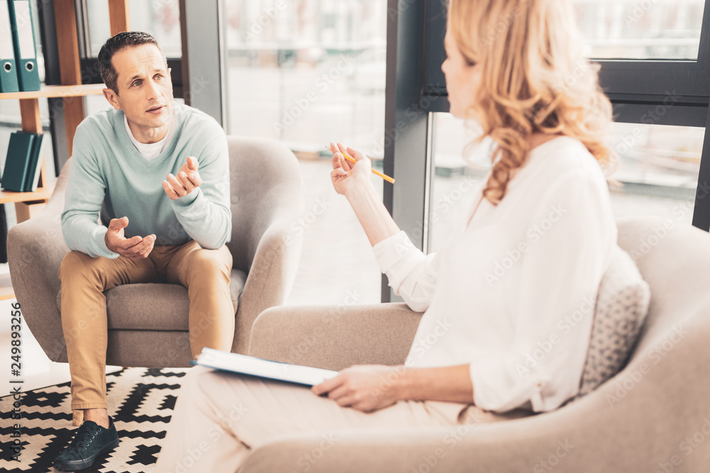 Fototapeta premium Stressed family man sharing his problems with psychoanalyst
