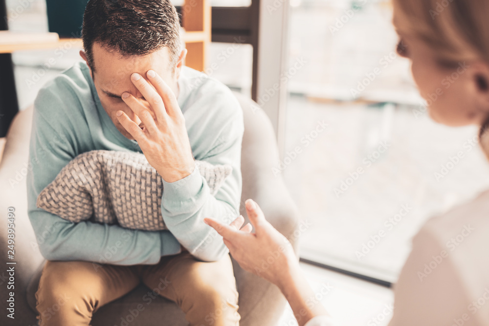 Fototapeta premium Stressed man feeling overloaded after busy workday