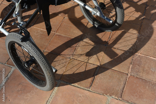 wheelchair and shadow on terracotta tiles