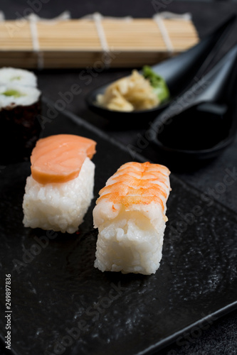 Sushi Set sashimi and sushi rolls served on stone slate 