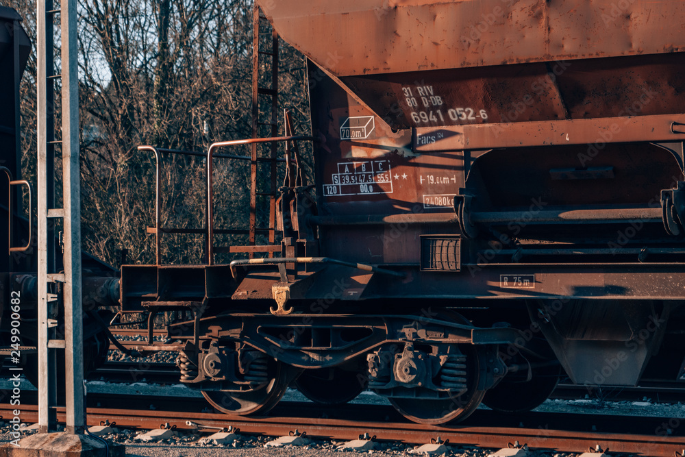 a rusty old cargo train with a red vintage look on a sidetrack