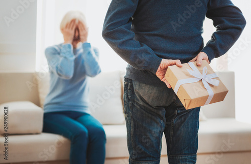 Attentive elderly man presenting his loving wife with gift