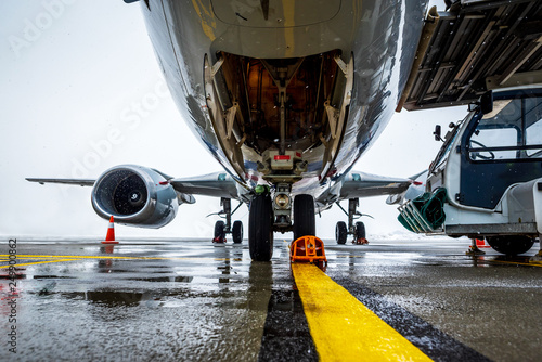 Passenger aircraft on maintenance and flight preparation. View under airplane fuselage in airport