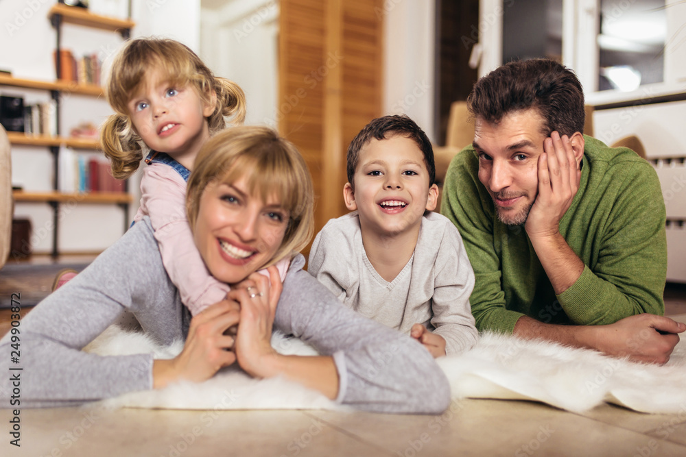 Happy family having fun on floor of in living room at home, laughing, selective focus. Happy family having fun on floor of in living room at home, laughing, selective focus.