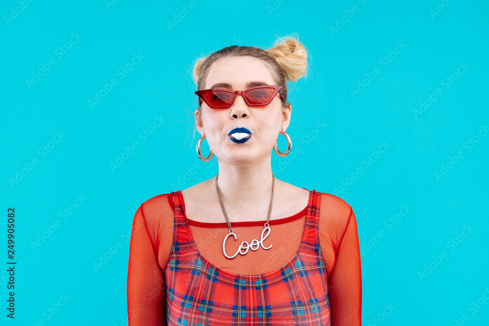 Blonde woman wearing red sunglasses chewing bubble gum Blonde woman wearing red sunglasses chewing bubble gum