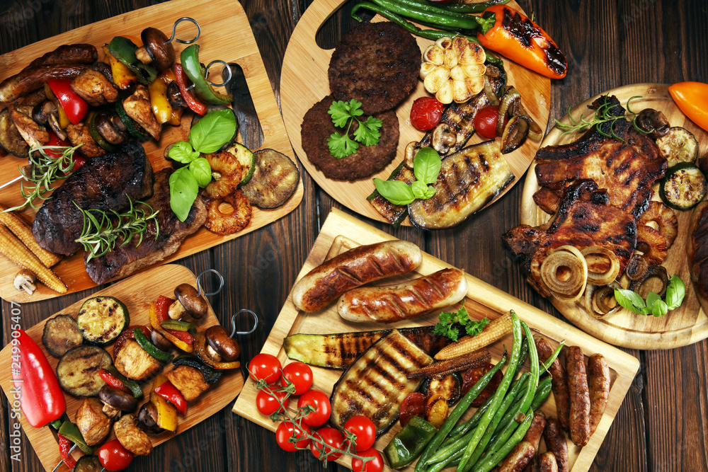 Assorted delicious grilled meat with vegetable on rustic table Assorted delicious grilled meat with vegetable on rustic table