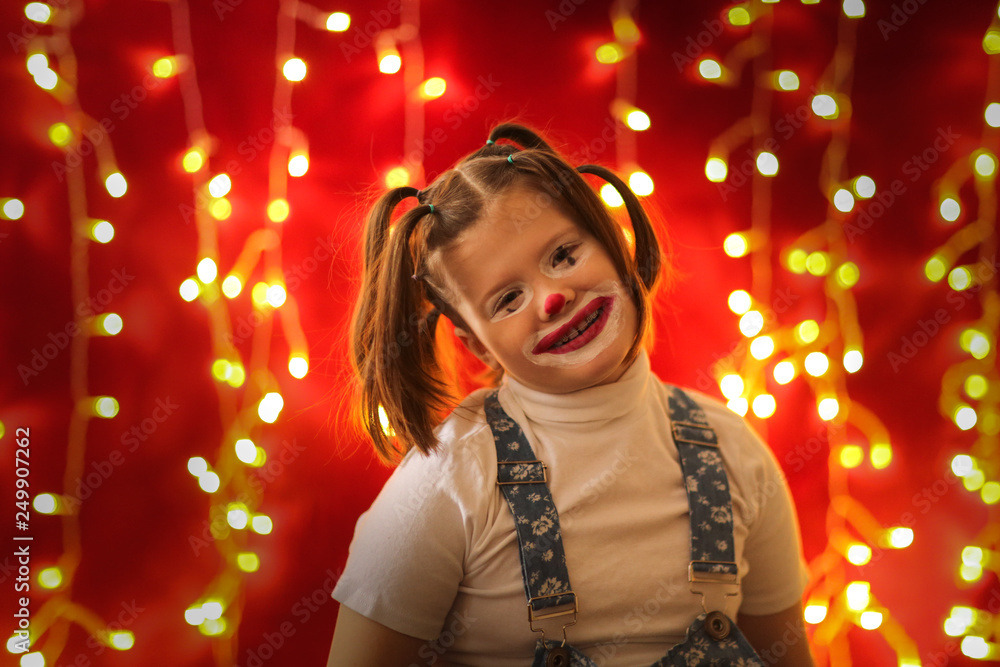 Emotional girl child painted under clown,fool's day Emotional girl child painted under clown,fool's day
