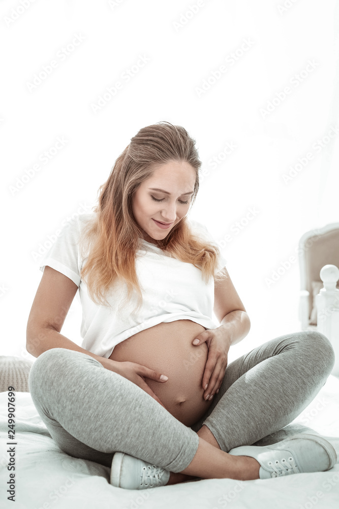 Positive pleasant lady sitting with crossed legs and observing Positive pleasant lady sitting with crossed legs and observing