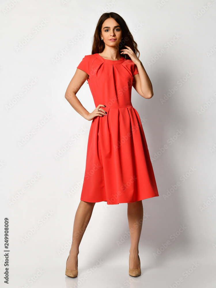 Young beautiful woman posing in new fashion casual red modern dress full body on a white Young beautiful woman posing in new fashion casual red modern dress full body on a white