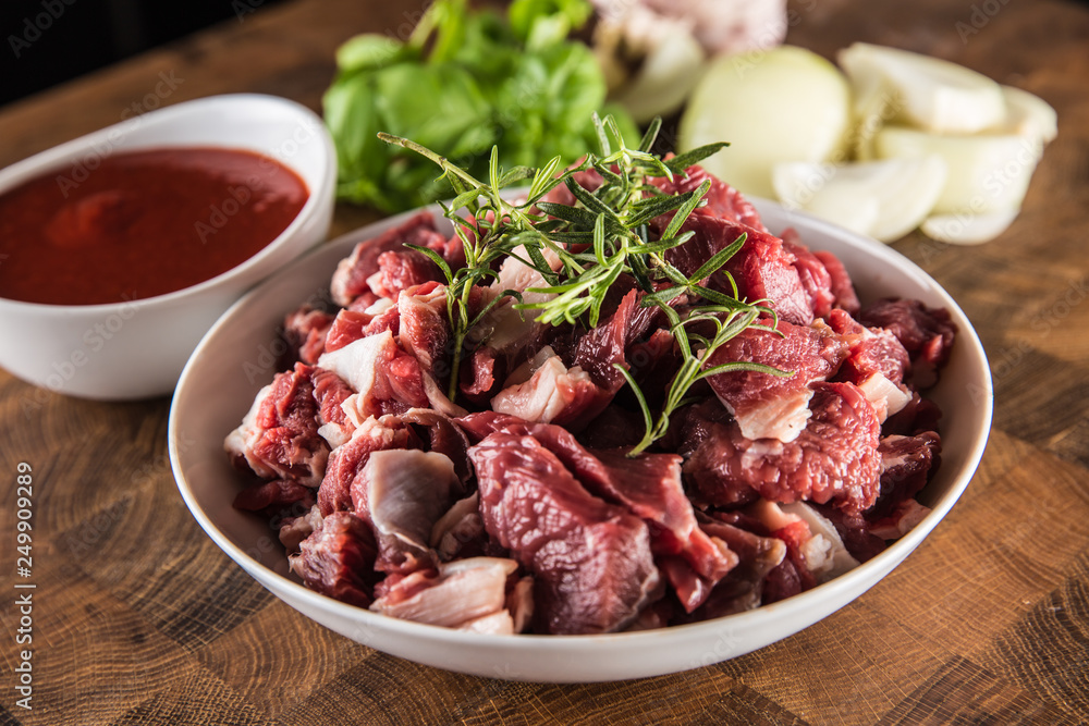 Sliced pieces of beef in plate with rosemary onion and garlic Sliced pieces of beef in plate with rosemary onion and garlic