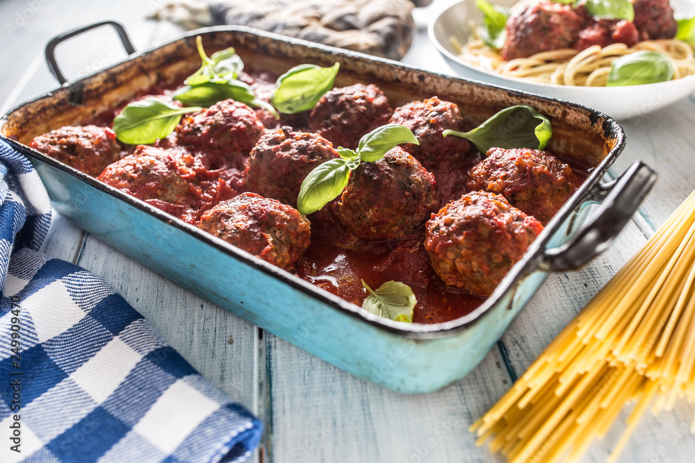 Delisious italian meal meat beef balls with pasta spaghetti and basil in vintage roaster pan