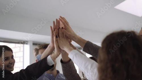 A young business team are happy for the work done. Raise your hands up, smile and look at the camera. Close up