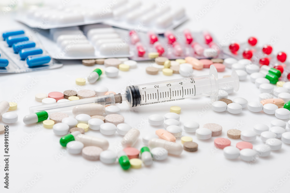 Pills capsules and syringe on white background Pills capsules and syringe on white background