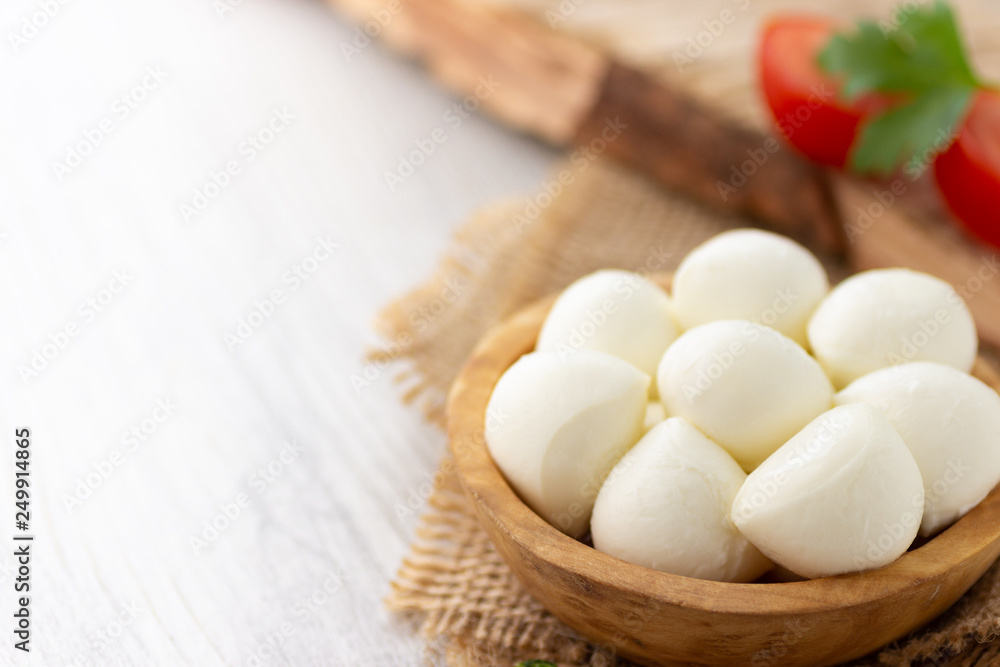Mozzarella cheese in wooden bowl. Rustic style. Mozzarella cheese in wooden bowl. Rustic style.