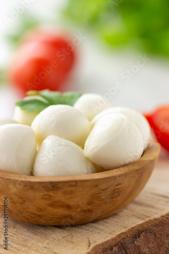 Mozzarella cheese in wooden bowl. Rustic style.