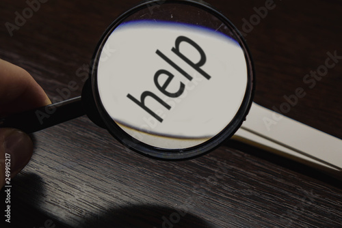Inscription HELP enlarged in magnifying glass magnifier