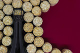 Black champagne bottle surrounded of many champagne corks