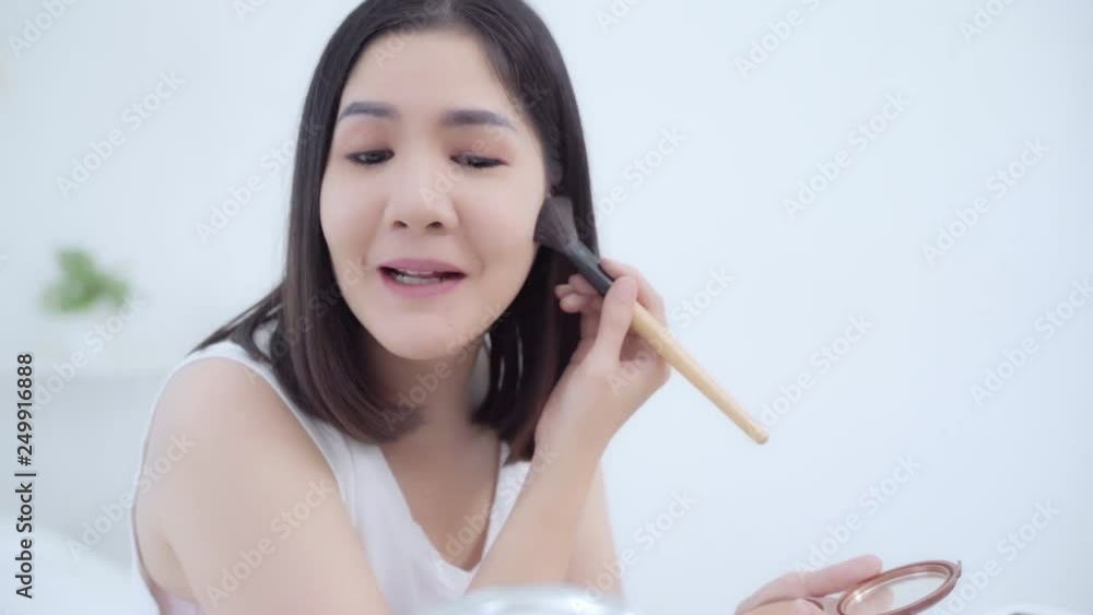 Beauty blogger present beauty cosmetics sitting in front camera for recording video. Happy beautiful young Asian woman use cosmetics review make up tutorial broadcast live video to social network. Beauty blogger present beauty cosmetics sitting in front camera for recording video. Happy beautiful young Asian woman use cosmetics review make up tutorial broadcast live video to social network.