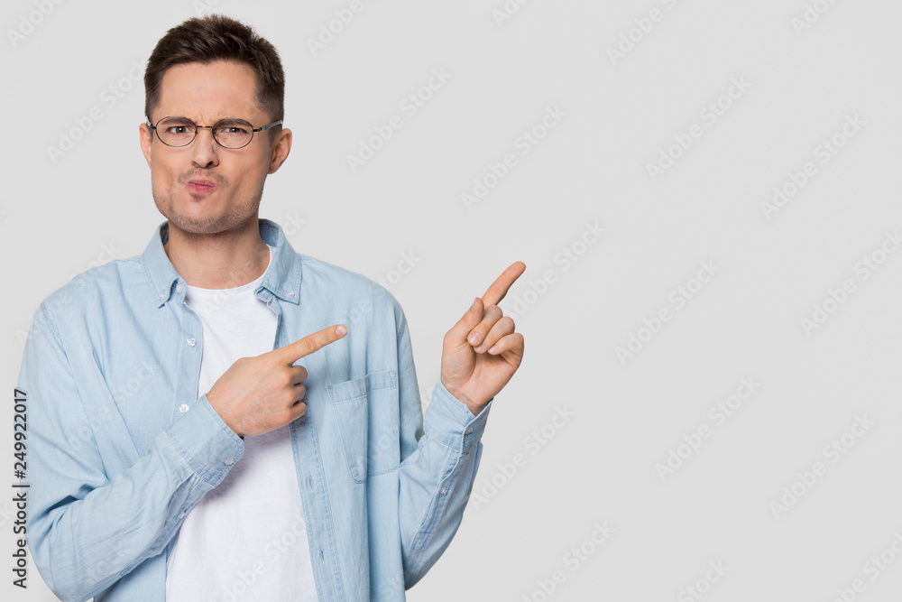 Confused bewildered man pointing fingers at copyspace feeling distrustful Confused bewildered man pointing fingers at copyspace feeling distrustful