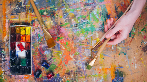 Woman hand holding a brush and painting colorfull abstract oil picture.