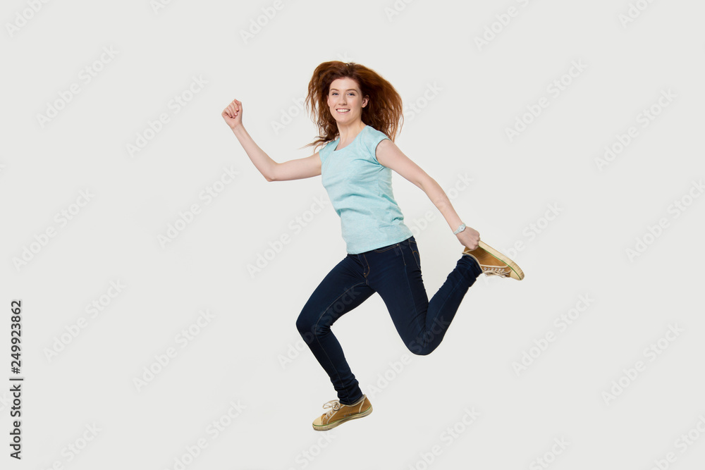 Happy active fit woman running hurrying jumping in air