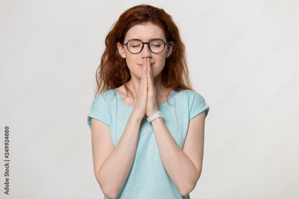 Happy redhead grateful woman join hands praying with hope meditating Happy redhead grateful woman join hands praying with hope meditating