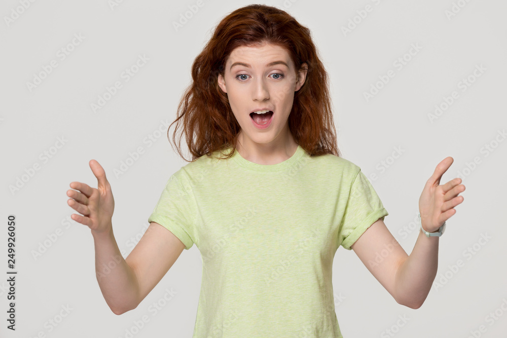 Shocked amazed redhead woman showing something big looking at hands Shocked amazed redhead woman showing something big looking at hands