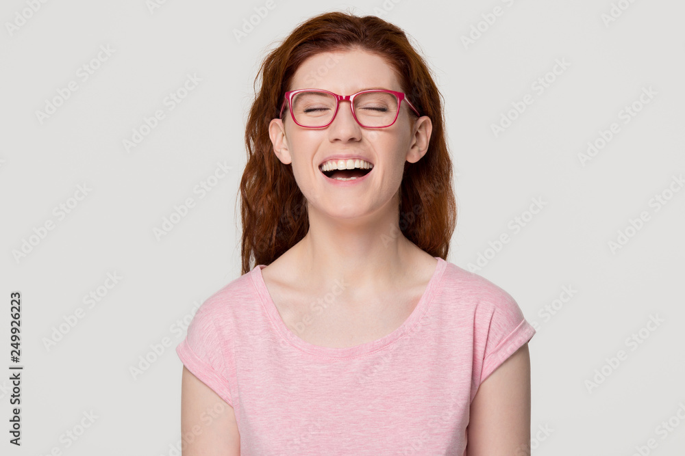 Happy funny redhead girl laughing out loud at humorous joke