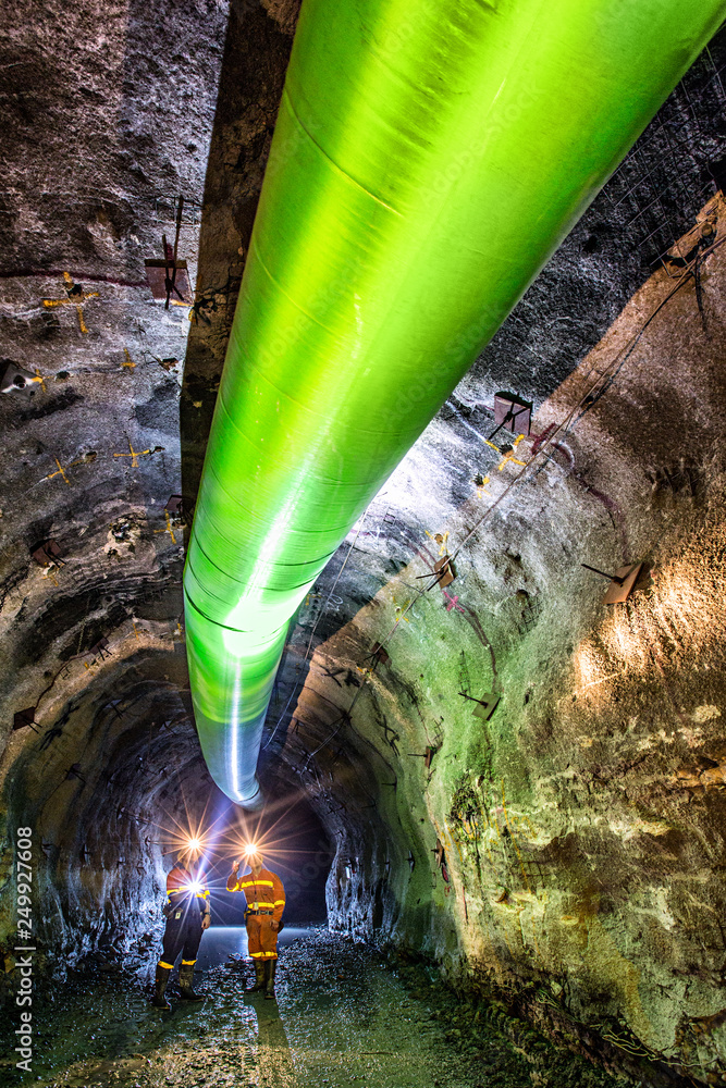 Miners inspecting an underground ventilation system in a gold mine in ...