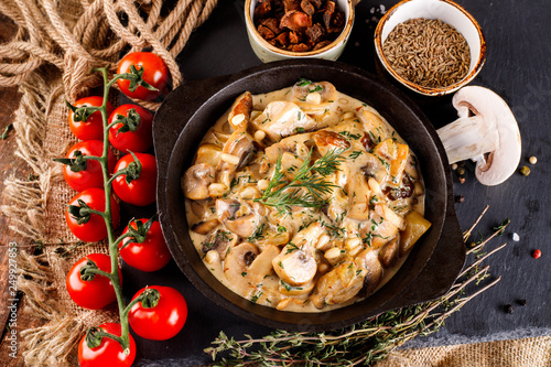 Mushrooms in cream sauce, julienne, champignon, products for cooking on the background of shale black Board