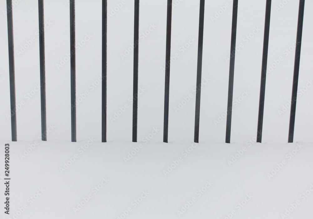 Metal black fence in the snow Metal black fence in the snow