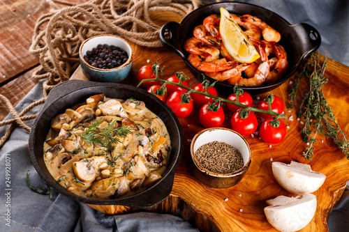 Fried large shrimp in tomato sauce with olive oil,Mushrooms in cream sauce, julienne, champignon, products for cooking