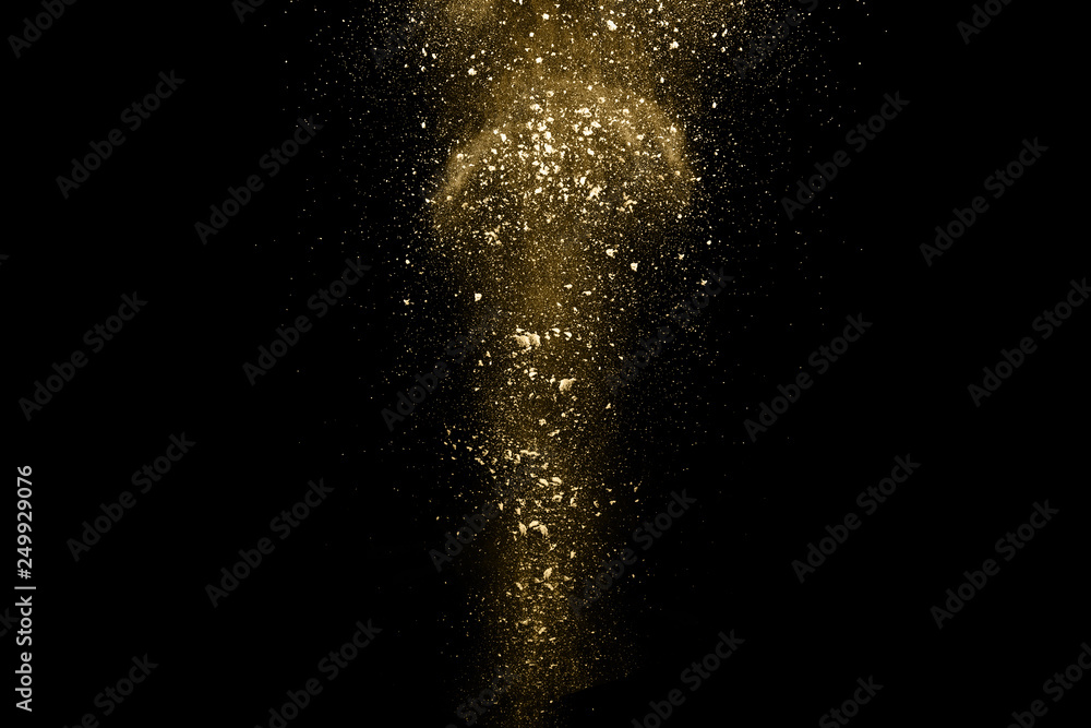 Golden powder explosion on black background. Freeze motion. Golden powder explosion on black background. Freeze motion.